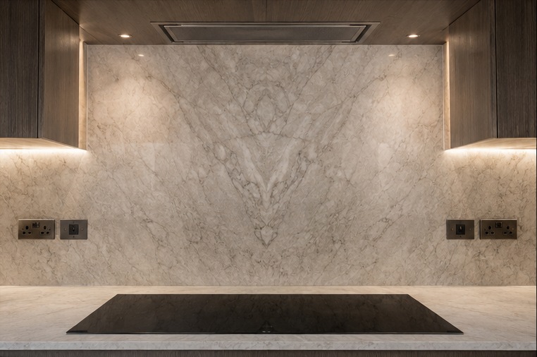 Primrose Hill Stone & Brass Kitchen — Bookmatched stone splashback and lighting